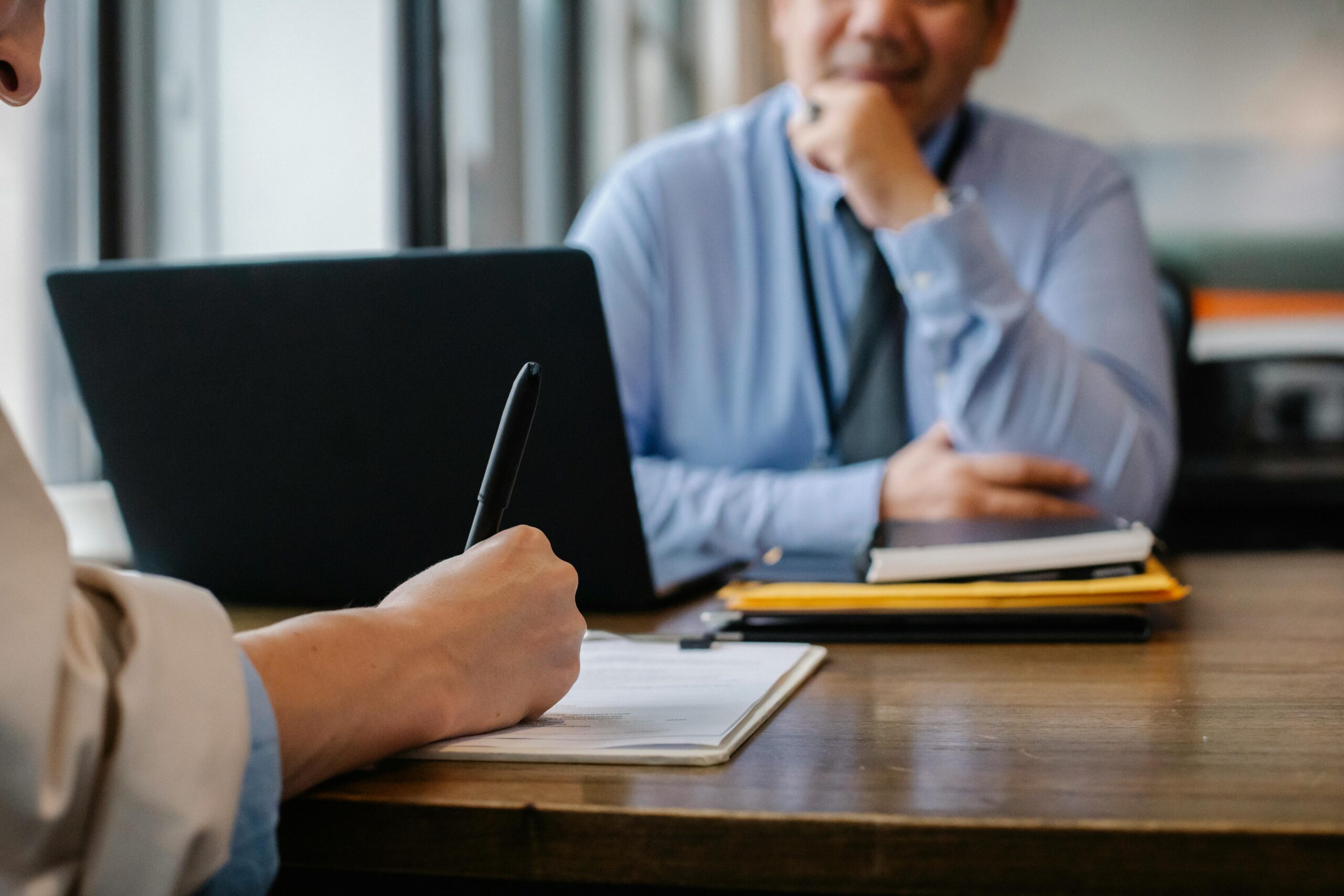 Person taking notes during a job interview.